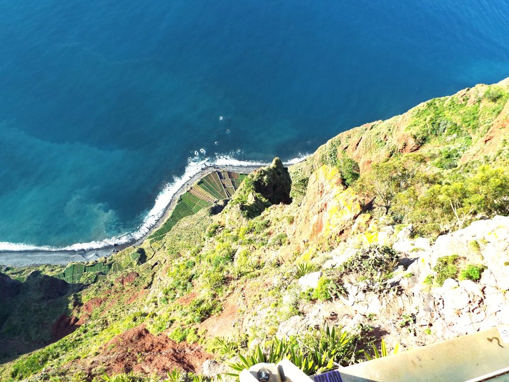 Widok z platformy Cabo Girão pionowo w dół na pola fajãs i ocean