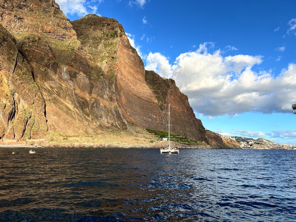 Żaglówka u stóp klifu Cabo Girão widzianego z oceanu