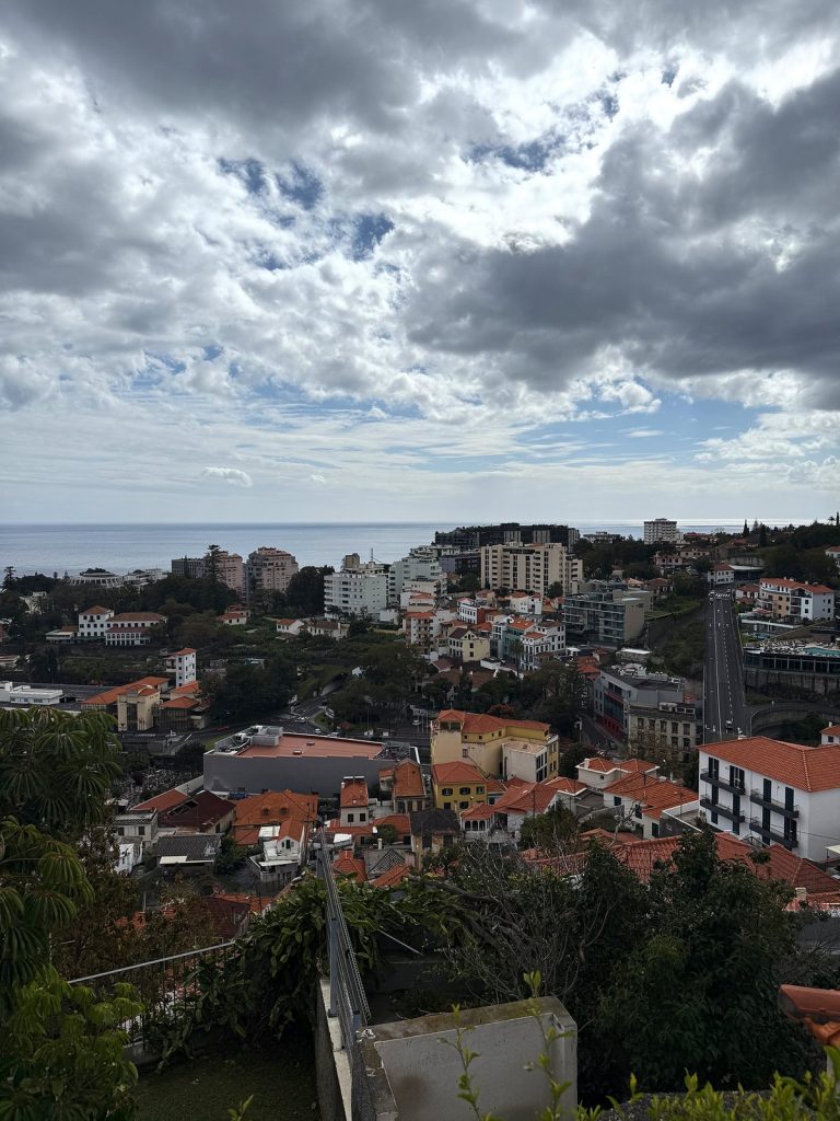 Ciemne chmury nad dachami Funchal, w oddali ocean