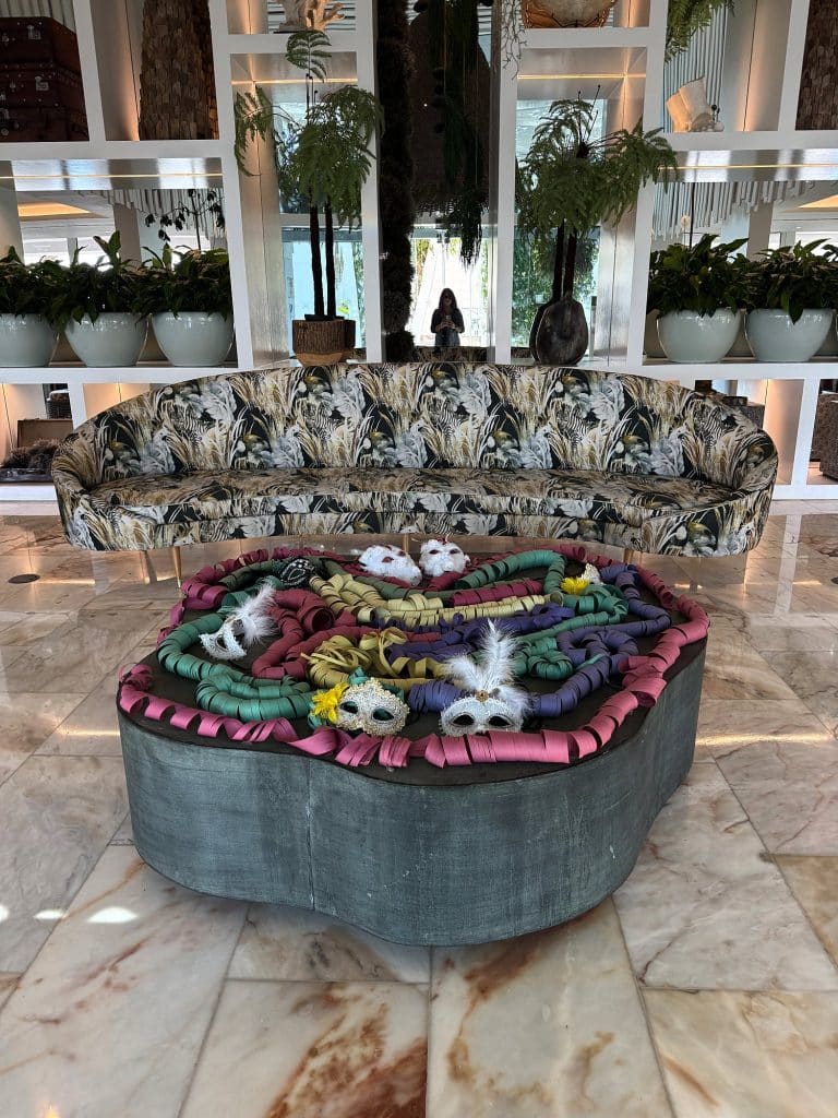 Kolorowe maski karnawałowe na okrągłym stole w hotelowym lobby