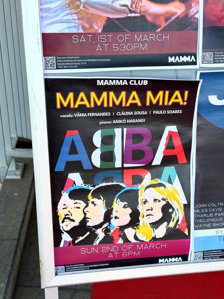 Kolorowy plakat koncertu „Mamma Mia!” z napisem ABBA i rysunkiem czterech twarzy, wywieszony w muzeum MAMMA