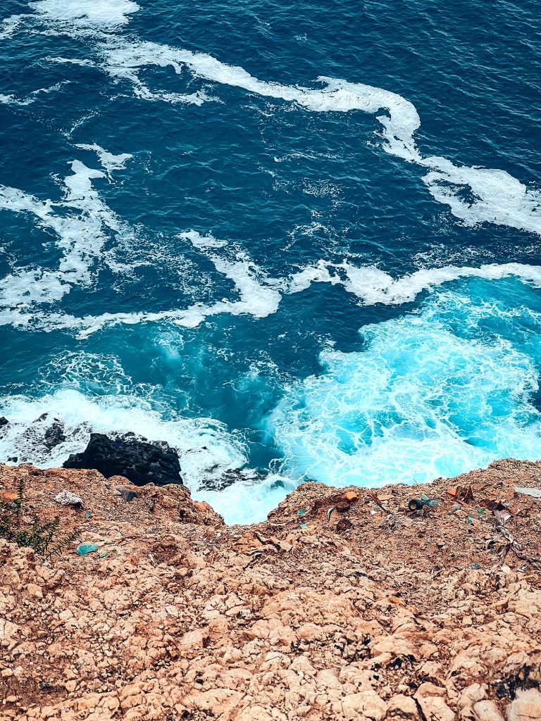Turkusowy ocean rozbijający się o skały pod klifami Ponta de São Lourenço